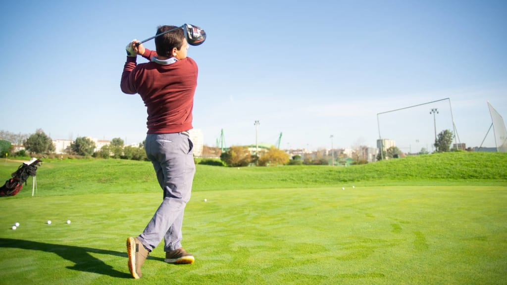 A Man in Red Sweater Playing Golf